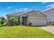 Inviting home exterior showcasing lush green lawn, a paver driveway, and attached two-car garage with a blue sky at 5133 Chickadee St, St Cloud, FL 34771
