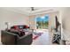 Well-lit living room showcasing tile floors, modern furniture, and a patio overlooking the serene lake at 5133 Chickadee St, St Cloud, FL 34771