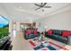 Open-concept living room with tile flooring, a modern ceiling fan, and comfortable black leather furniture at 5133 Chickadee St, St Cloud, FL 34771