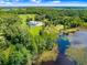 Expansive aerial view showcasing the property's lakefront location and surrounding greenery at 5150 Gentry Oaks Pl, St Cloud, FL 34772