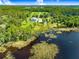 Aerial view of the home, lake and land with abundant trees surrounding the area at 5150 Gentry Oaks Pl, St Cloud, FL 34772
