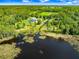 Expansive aerial view showcasing the property's lakefront location and surrounding trees at 5150 Gentry Oaks Pl, St Cloud, FL 34772
