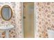 Bathroom with pedestal sink and enclosed shower with decorative floral wallpaper at 5150 Gentry Oaks Pl, St Cloud, FL 34772