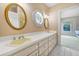 Bathroom with double sinks, octagonal window, and framed oval mirrors at 5150 Gentry Oaks Pl, St Cloud, FL 34772