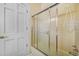 Neutral-toned bathroom featuring a bathtub with sliding glass door and tiled walls at 5150 Gentry Oaks Pl, St Cloud, FL 34772