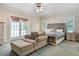 Comfortable main bedroom with chair and ottoman, ensuite, and natural light at 5150 Gentry Oaks Pl, St Cloud, FL 34772