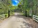 Private gated driveway entrance providing security and seclusion with mature trees and established foliage at 5150 Gentry Oaks Pl, St Cloud, FL 34772