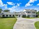 Stately two-story home features white columns, lush landscaping, and a long driveway at 5150 Gentry Oaks Pl, St Cloud, FL 34772