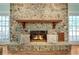 Beautiful stone fireplace with a wooden mantel and cozy fire at 5150 Gentry Oaks Pl, St Cloud, FL 34772