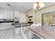 Eat-in kitchen with white cabinets, black countertops, stainless appliances, and counter seating at 5150 Gentry Oaks Pl, St Cloud, FL 34772