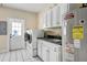 Laundry room features white cabinets, gray countertops, washer and dryer, and utility sink at 5150 Gentry Oaks Pl, St Cloud, FL 34772