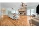 Open living room featuring hardwood floors, stone fireplace, and comfortable seating arrangement at 5150 Gentry Oaks Pl, St Cloud, FL 34772