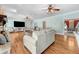 Bright living room featuring hardwood floors, comfortable seating, and seamless transition to dining area at 5150 Gentry Oaks Pl, St Cloud, FL 34772