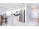 Bright kitchen with white cabinetry, stainless steel appliances, and a breakfast bar seating area at 56 Levee Ln, Ormond Beach, FL 32174
