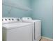 Functional laundry room with a washer, dryer and overhead shelving for convenient storage at 56 Levee Ln, Ormond Beach, FL 32174