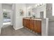 Bathroom featuring double sinks, wood cabinets, granite counters and tile flooring at 6479 Apple St, St Cloud, FL 34771