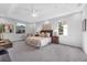Bright and airy primary bedroom with tray ceiling, featuring carpet, modern furniture, and natural light at 6479 Apple St, St Cloud, FL 34771