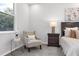 Bright bedroom nook featuring an armchair next to a nightstand and plush bedroom at 6479 Apple St, St Cloud, FL 34771