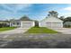 Bright home exterior featuring a well-manicured lawn and a spacious three-car garage for ample parking at 6479 Apple St, St Cloud, FL 34771