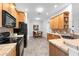 Bright kitchen with tile countertops, black appliances and a view of dining area and front entry at 6479 Apple St, St Cloud, FL 34771