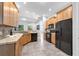 Kitchen with wooden cabinets and black appliances next to a dining area and view of backyard at 6479 Apple St, St Cloud, FL 34771