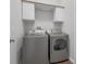 Well-equipped laundry room with modern washer and dryer, complemented by upper cabinets at 6479 Apple St, St Cloud, FL 34771