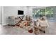 Bright living room featuring comfortable armchairs, a modern TV, and a sliding door that opens to the backyard at 6479 Apple St, St Cloud, FL 34771