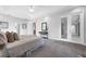 Spacious main bedroom with tray ceilings, carpet, and french doors leading to the backyard at 6479 Apple St, St Cloud, FL 34771