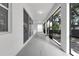 Long screened patio featuring gray floors, windows, and a view of trees at 6479 Apple St, St Cloud, FL 34771