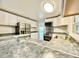 Bright kitchen boasts gray countertops, stainless steel appliances, and white cabinets, seamlessly blending style and functionality at 713 Wood Ln, Kissimmee, FL 34759