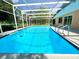 Sparkling screened-in pool surrounded by lush greenery at 713 Wood Ln, Kissimmee, FL 34759