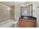 Bathroom with a shower, bathtub, and wooden vanity, with a mirror, lights, and a toilet at 7468 Excitement Dr # 101, Reunion, FL 34747
