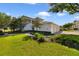 Beautiful lawn with lush landscaping, leading to a white building with well-maintained garages at 7468 Excitement Dr # 101, Reunion, FL 34747