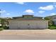 Garage with four doors and ample parking space, set against a blue sky with lush green trees at 7468 Excitement Dr # 101, Reunion, FL 34747