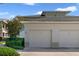 Attached garage with white doors and manicured landscaping, complementing the home's exterior at 7468 Excitement Dr # 101, Reunion, FL 34747