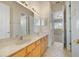Bathroom featuring double sinks, a large mirror and wood cabinetry at 7740 Linkside Loop, Reunion, FL 34747