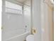 Bathroom with a white tiled shower/tub combo and window at 7740 Linkside Loop, Reunion, FL 34747