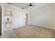This bedroom features neutral carpet, an ensuite bathroom, and a doorway to the hallway at 7740 Linkside Loop, Reunion, FL 34747