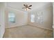 Spacious, carpeted bedroom with large windows and a ceiling fan at 7740 Linkside Loop, Reunion, FL 34747