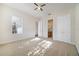 Carpeted bedroom with ceiling fan, window and access to an ensuite bathroom at 7740 Linkside Loop, Reunion, FL 34747