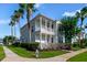 Charming two-story home with a double balcony, palm trees, and beautiful landscaping at 7740 Linkside Loop, Reunion, FL 34747