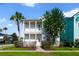 Inviting two-story home features a double balcony and a lush, flowering tree in the front yard at 7740 Linkside Loop, Reunion, FL 34747