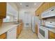 Well-lit kitchen featuring white appliances, light wood cabinets and tile floors at 7740 Linkside Loop, Reunion, FL 34747