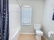 Bright bathroom featuring tile flooring, a window, and a shower/tub combo, providing a clean and functional space at 805 Suffolk Pl, Davenport, FL 33896