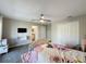 Cozy bedroom featuring carpet flooring, ceiling fan, TV, closet, and an ensuite bathroom, offering a relaxing retreat at 805 Suffolk Pl, Davenport, FL 33896