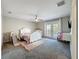 Comfortable bedroom with neutral walls, carpet flooring, a ceiling fan, and access to a private balcony through double doors at 805 Suffolk Pl, Davenport, FL 33896