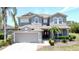 Charming two-story home with gray stucco, neutral trim, attached two-car garage, and well manicured landscaping at 805 Suffolk Pl, Davenport, FL 33896