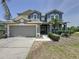 Elegant two-story home with a two-car garage, manicured landscaping, and a covered front entryway at 805 Suffolk Pl, Davenport, FL 33896