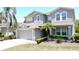 Charming two-story home with gray stucco, neutral trim, attached two-car garage, and well manicured landscaping at 805 Suffolk Pl, Davenport, FL 33896