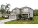 Attractive two-story home boasting a well-maintained lawn, a 2-car garage, and lush landscaping at 805 Suffolk Pl, Davenport, FL 33896